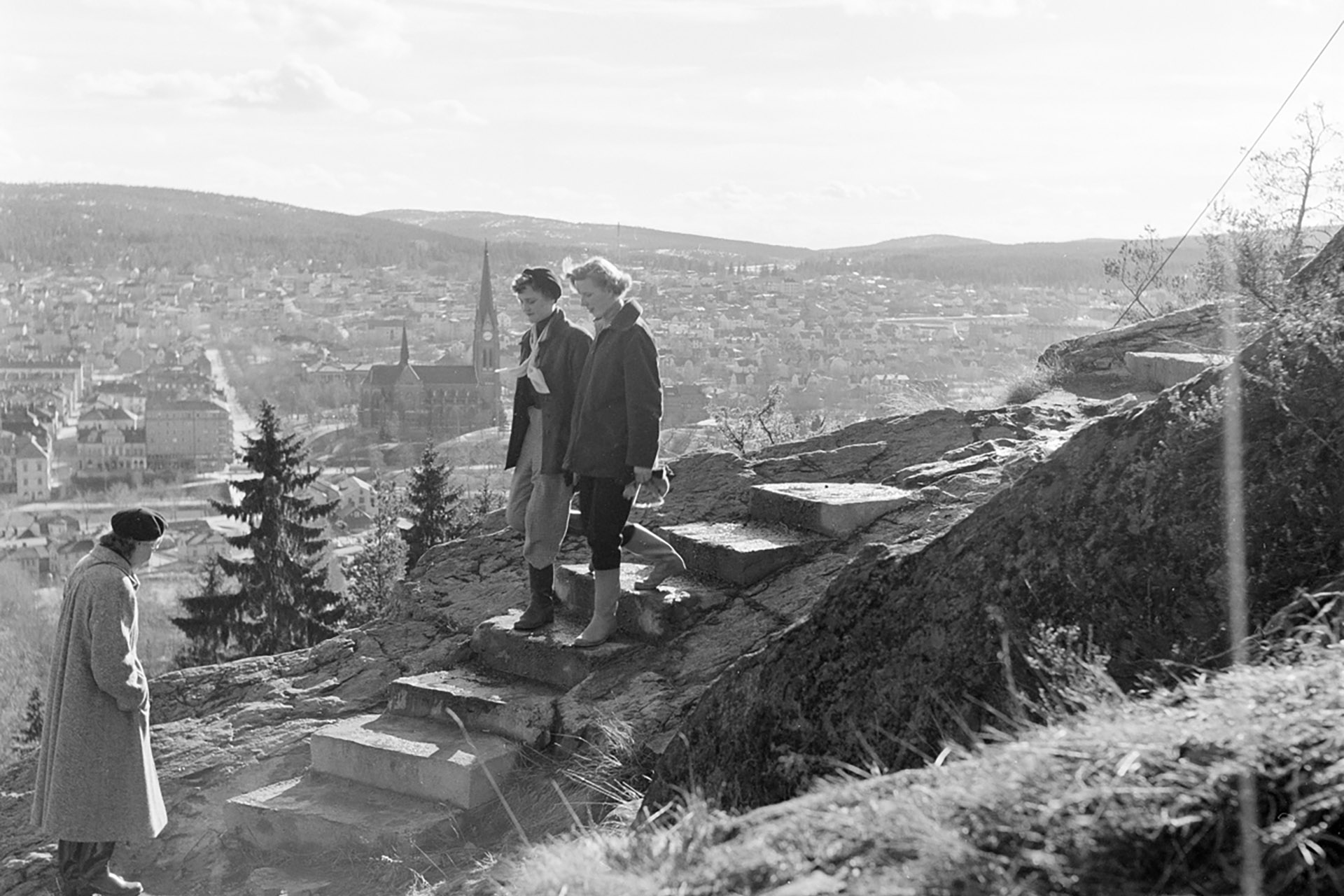 Tre kvinnor går i trappan som går upp till berget. Foto: Sundsvalls museums fotoarkiv.
